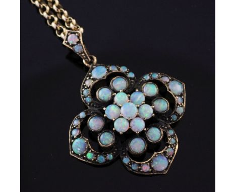 An early 20th century gold and white opal cluster pendant on a later 9ct gold chain, the pendant of pierced quatrefoil form, 