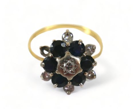 A 18ct diamond and sapphire flowerhead ring, (missing one diamond a/f), with six brilliant-cut diamonds, each approximately 2