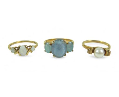 A group of three dress rings, comprising a three stone opal ring, largest stone 12.02 by 10.16mm, with a black glass backing 