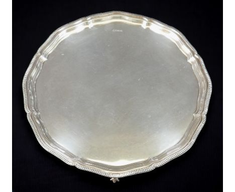 An Elizabeth II silver tray, with scalloped and cast bead edge, raised on three claw and ball feet, Cooper Brothers &amp; Son