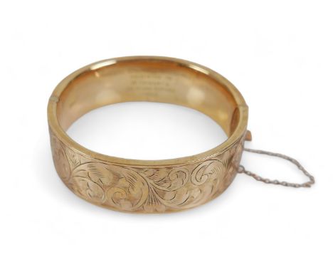 A 9ct yellow gold presentation engraved hinged bangle, 25.1 grams. 60mm by 63mm by 19mm external.In good condition, clasp goo