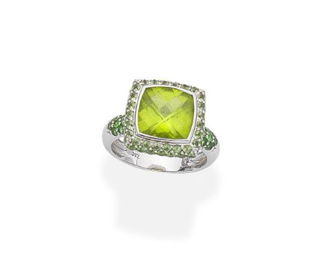 PERIDOT AND TSAVORITE GARNET RINGSet to the centre with a checkerboard-cut peridot in a double surround of circular-cut perid