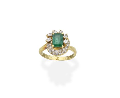 EMERALD AND DIAMOND RINGThe central step-cut emerald, within an asymmetrical baguette and brilliant-cut diamond surround, rin