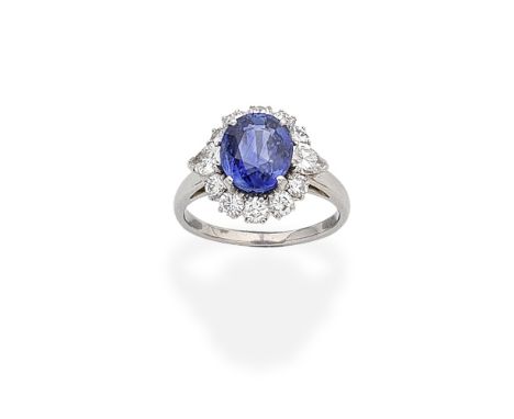 BULGARI: SAPPHIRE AND DIAMOND CLUSTER RINGThe oval-cut sapphire within a surround of brilliant and pear-shaped diamonds,  dia