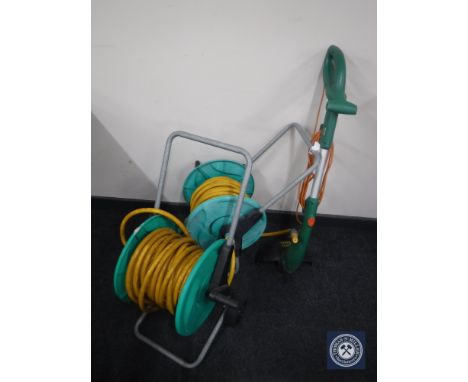 Two hose pipe on reels and a Black &amp; Decker strimmer 
