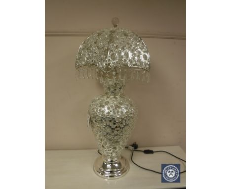 A highly ornate white metal and crystal drop table lamp with revolving shade. 