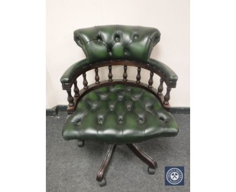 A green button leather low backed office chair. 