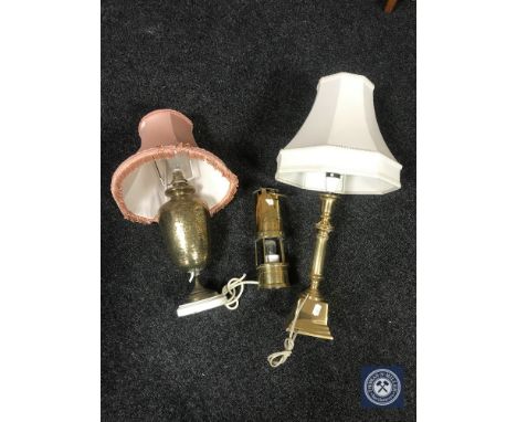 A brass miners lamp converted to a table lamp together with two further brass table lamps 