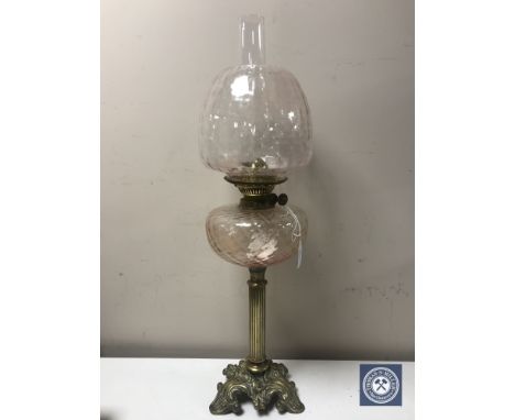 A Victorian brass oil lamp with glass reservoir, chimney and shade 