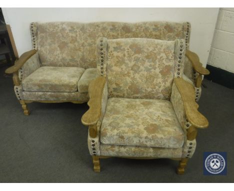 An oak framed three seater settee and armchair in floral tapestry fabric  