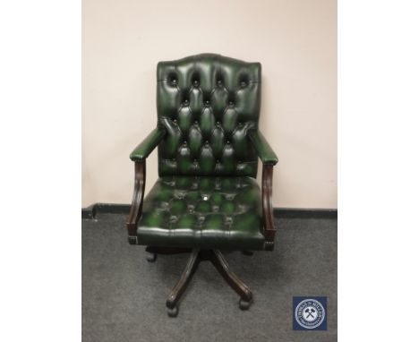 A green button leather high backed office chair. 