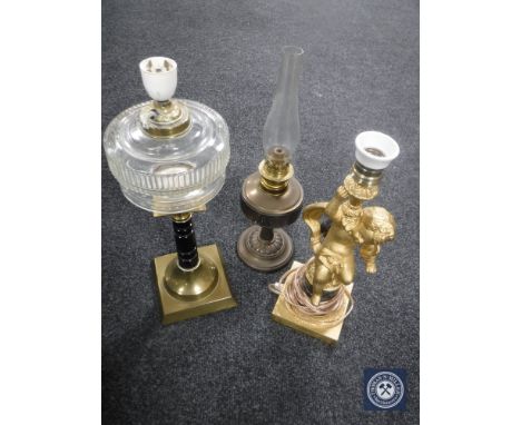 An oil lamp, converted oil lamp and gilt metal cherub lamp (3)