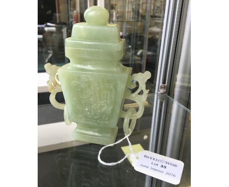 A carved jade lidded vase with decorated front with twin handles, one handle A/F.