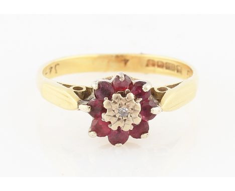 SOLD WITHOUT BUYERS PREMIUM AND VAT. An 18ct yellow gold ruby and diamond cluster ring in flower head design, set with a cent