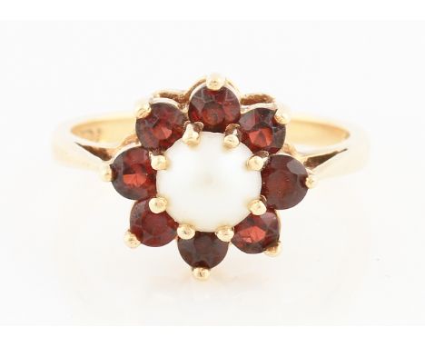 SOLD WITHOUT BUYERS PREMIUM AND VAT. A 9ct yellow gold pearl and garnet cluster ring, set with a central pearl surrounded by 