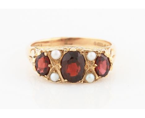 SOLD WITHOUT BUYERS PREMIUM AND VAT. An Edwardian style 9ct yellow gold garnet and seed pearl ring, set with three graduated 