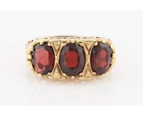 SOLD WITHOUT BUYERS PREMIUM AND VAT. An Edwardian style 9ct yellow gold garnet ring, set with three graduated garnets, hallma