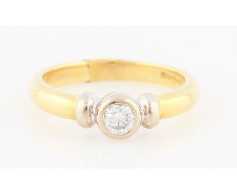 SOLD WITHOUT BUYERS PREMIUM AND VAT. An 18ct yellow and white gold diamond solitaire ring, rub over set with a round brillian