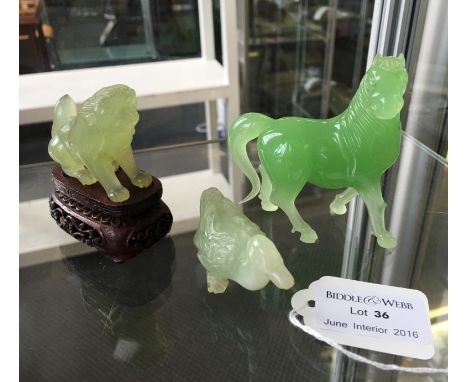 Two carved jade sculptures including a seated mythical animal and a duck, together with a green glass horse.