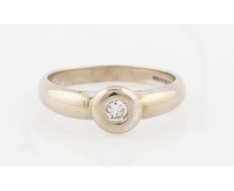 SOLD WITHOUT BUYERS PREMIUM AND VAT. A 9ct white gold diamond solitaire ring, rub over set with a round brilliant cut diamond