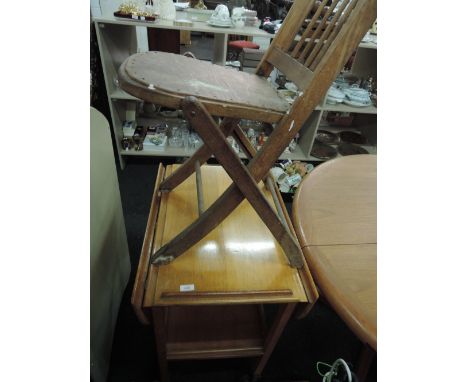 A folding chair and a light stained tea trolley