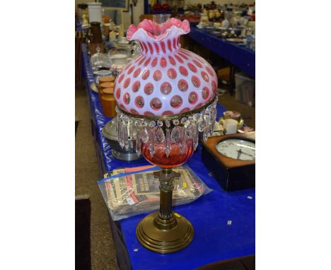 Large oil lamp with cranberry tinted and overlaid shade, cranberry tinted font and brass base
