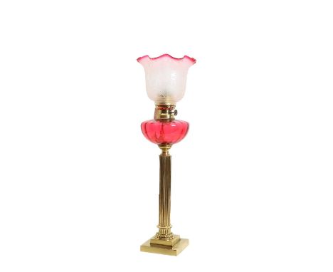 A Victorian brass oil lamp with fluted column with cranberry glass reservoir and etched clear glass shade,51cm high to fittin