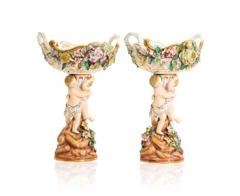 A pair of Meissen style porcelain figural comports, late 19th century, each modelled with a figural column below a floral enc