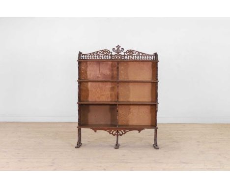 An oak waterfall bookcase, early 20th century, with pierced scrolling decoration to the back and sides, set with four graduat