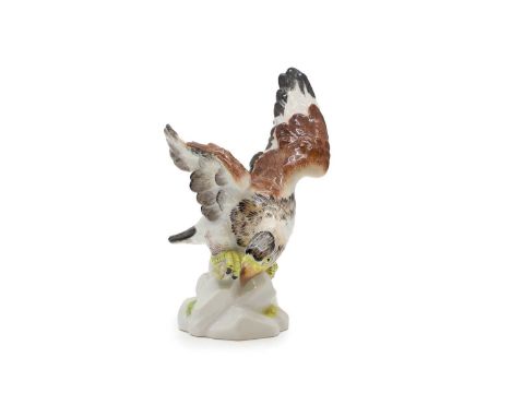 A Meissen group, 20th century, modelled as an eagle perched on a branch with a bowed head, incised to base 108C with blue cro