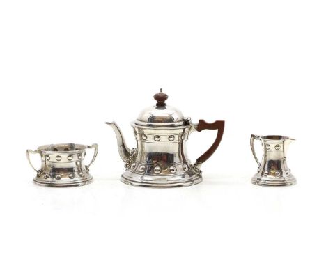 An Arts and Crafts silver three piece tea service, by Ackroyd Rhodes, 1905 and 1906, retailed by Rhodes and Sons, Bradford, e