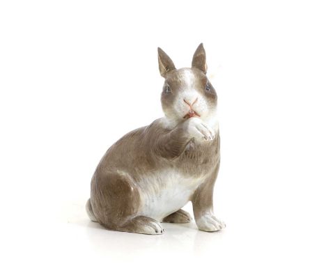 A Meissen porcelain model of a rabbit, late 19th century, seated licking its paw, underglaze blue crossed swords mark, incise