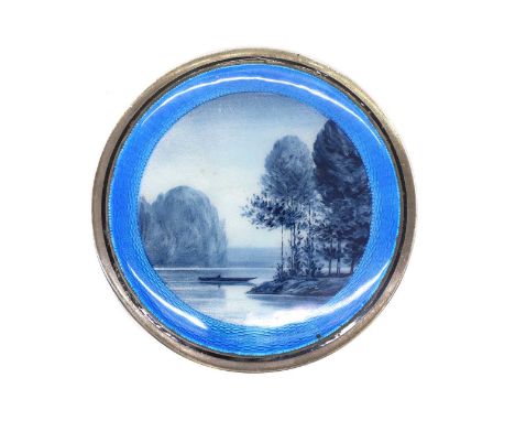 A silver and enamel box and cover London import 1922, enamelled with a lake scene, complete with a gilt interior,7.9cm diamet