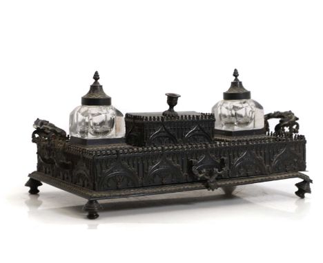 A bronze Gothic Revival desk stand, 19th century, complete with cut glass inkwells, with Gothic tracery sides,43.5cm wideCond