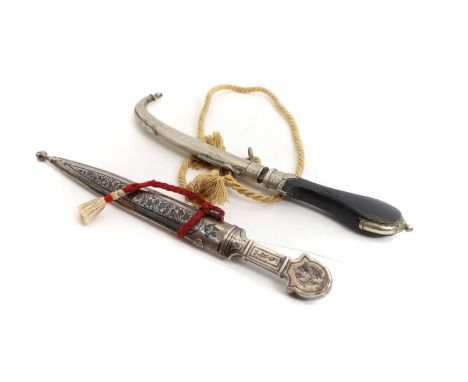 A Moroccan white metal jambiya  early 20th century, 8.5-inch blade with wooden handle, the scabbard with engraved decoration,