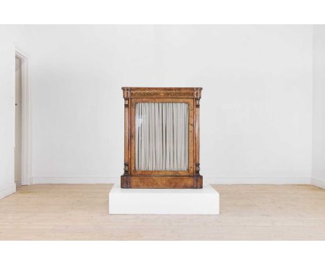 A Victorian walnut and marquetry pier cabinet, c.1860, the rectangular top above a glazed single door enclosing shelves, on a