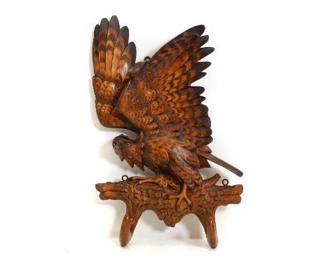 A beech wall hook, German, early to mid 20th cenutry, modelled as an eagle perched on a branch, with glass eyes, stamped 'Alb