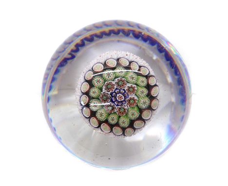 A Baccarat glass torsade paperweight c.1850, with concentric millefiori decoration enclosed with a blue and white torsade, al