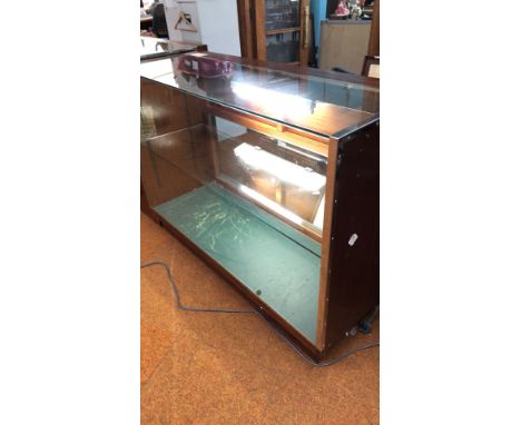 Pair of vintage wooden and glass display cabinets with interior lighting. One features a red velvet-lined base.