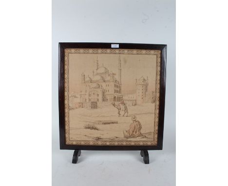 Early 20th Century Egyptian tapestry fire screen, depicting a mosque, camel and two figures, 53cm wide and 59cm high