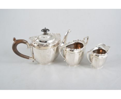 A silver three piece teaset, plain polished oval panelled body with  wavy line border on a plain oval foot, engraved "Harboro