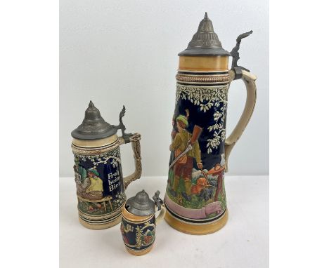 3 vintage ceramic German lidded steins all with traditional scenes. To include a very large 3 litre stein approx. 43cm tall. 