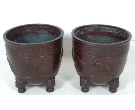 A pair of Japanese bronze jardinieres, circa 1910, decorated in relief with tigers in a rocky mountainous landscape, raised o