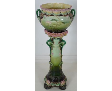 An Austrian Art Nouveau ceramic jardiniere and stand, modelled overall with water lily flowers and leaves in pinks, greens an