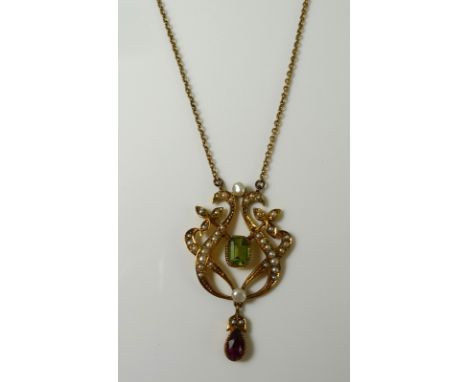 An Art Nouveau 15ct gold, peridot, ruby and seed pearl pendant of scrolled lyre form, in the suffragette colours, peridot 6 b