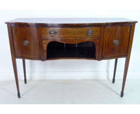 A George III mahogany, line inlaid and crossbanded sideboard, with serpentine shaped front, cupboards flanking central frieze