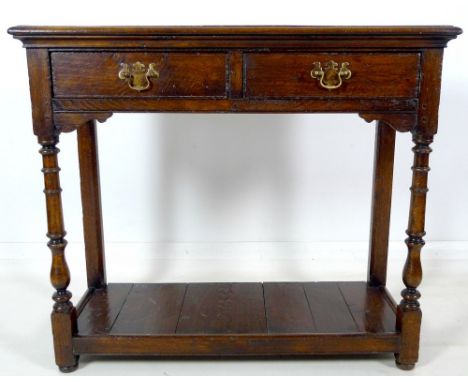 A 19th century oak hall table, with two frieze drawers, brass plate swan neck handles, cock beading, lower shelf, turned fron