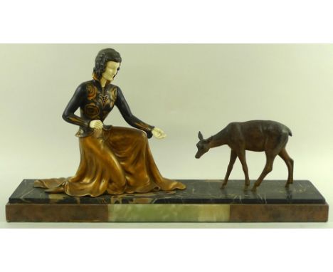 An Art Deco bronze and ivory sculpture, modelled as a well dressed lady crouching to feed a fawn, gilt detailing, signed Limo