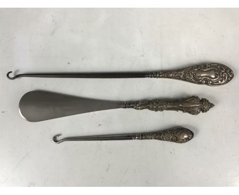 Three silver-handled button hooks