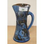 C.H. Brannam, an attractive Arts & Crafts fish jug covered in a blue and green glaze, having incised